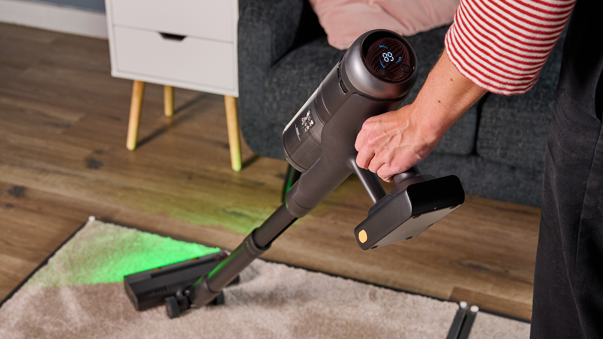 Tester using Roborock H60 Hub Ultra cordless vacuum on a carpet panel