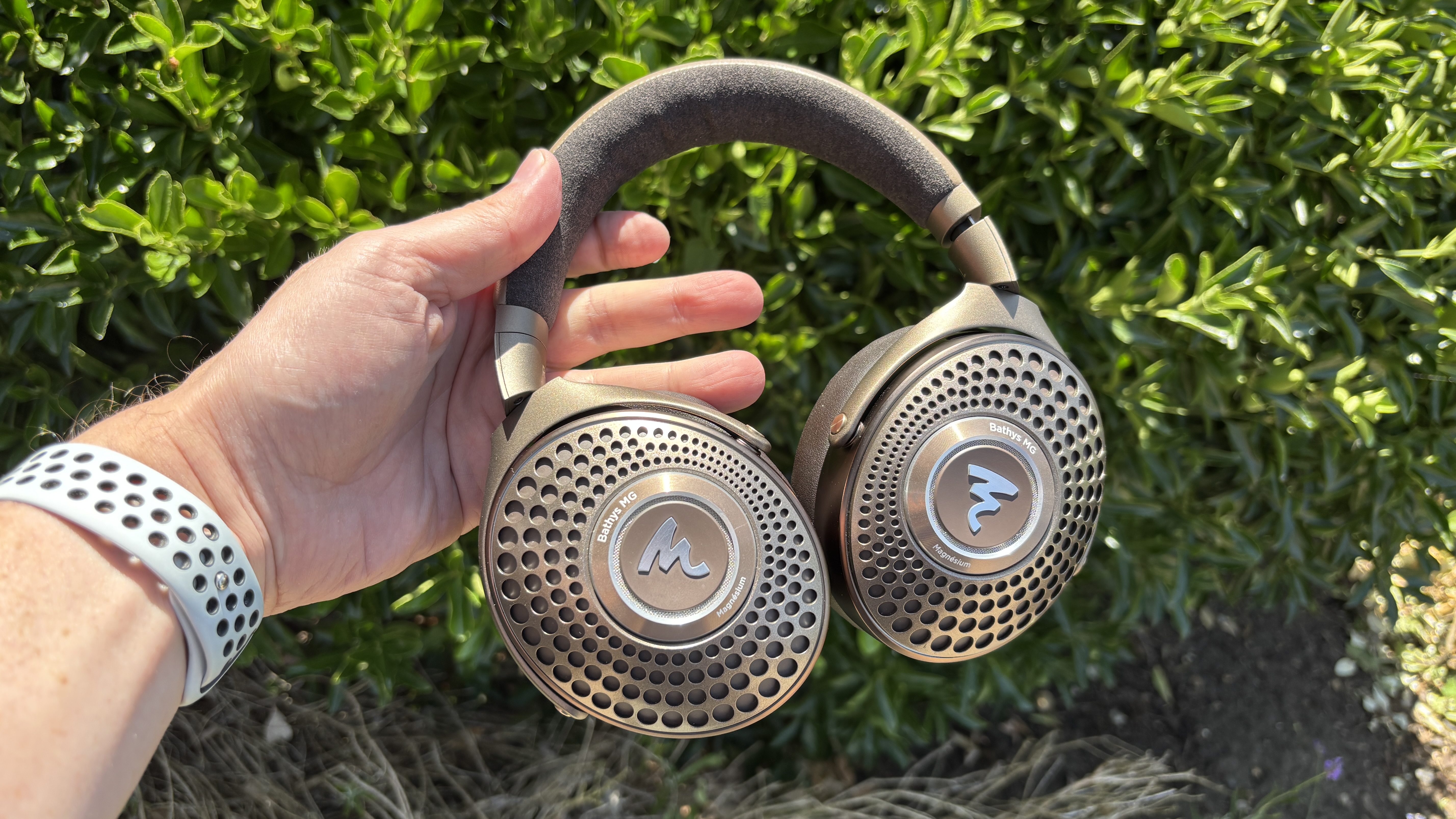 Focal Bathys Mg headphones held in hand outdoors