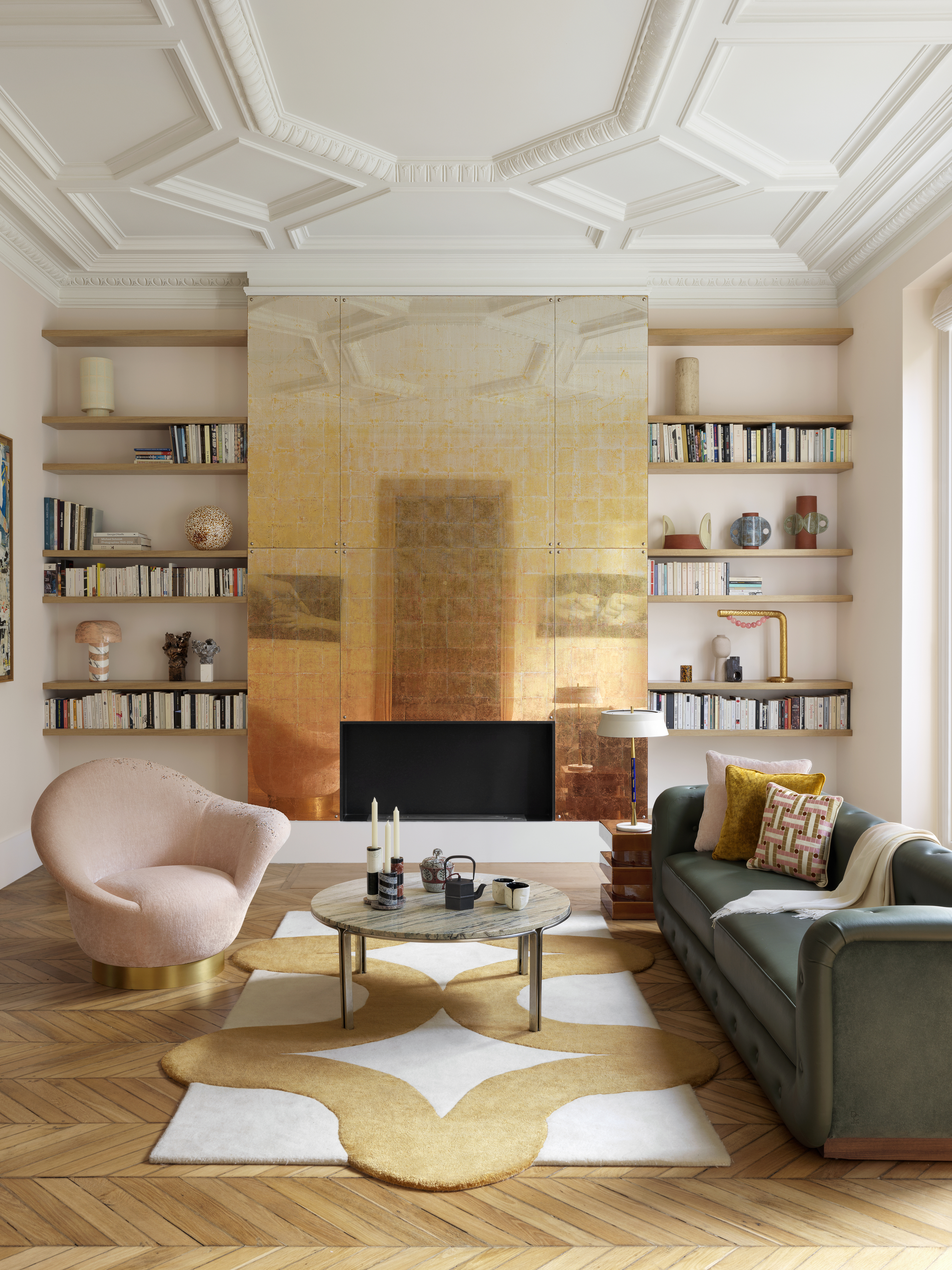 A fireplace designed in brass, with floating shelves next to it