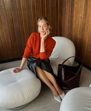 Anouk Yve wears a red jumper and leather midi skirt