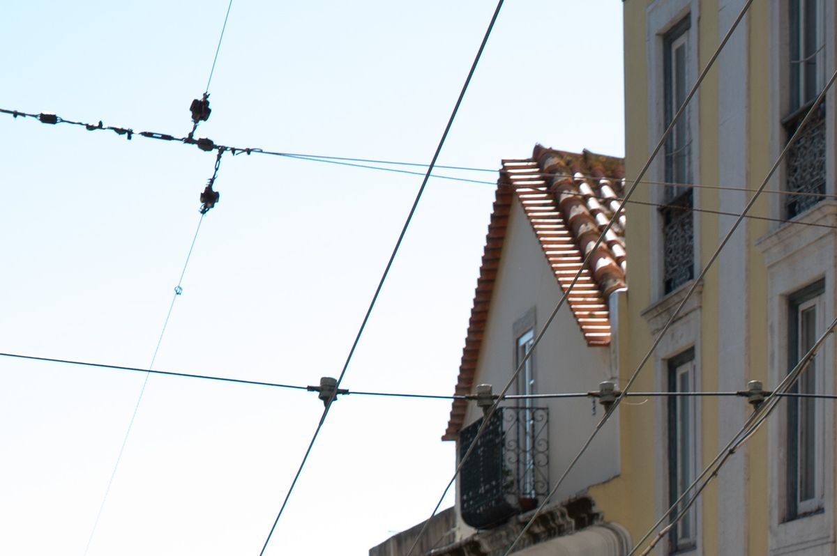 Closeups of like-like images shot with Sigma and Viltrox 35mm f/1.4 lenses - of a scene in Lisbon containing a yellow tram