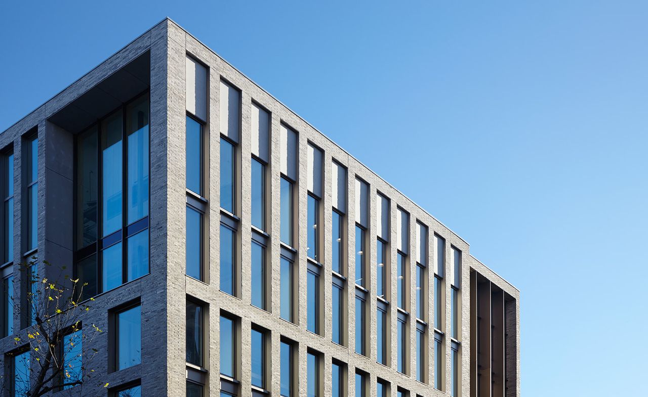 multi story building with a brick facade and extensive glazing