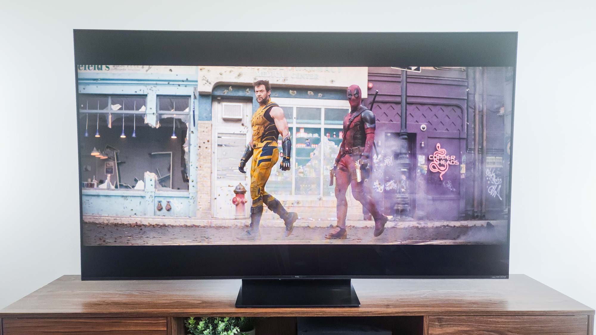 A TCL QM7K QD-Mini LED TV on a side table