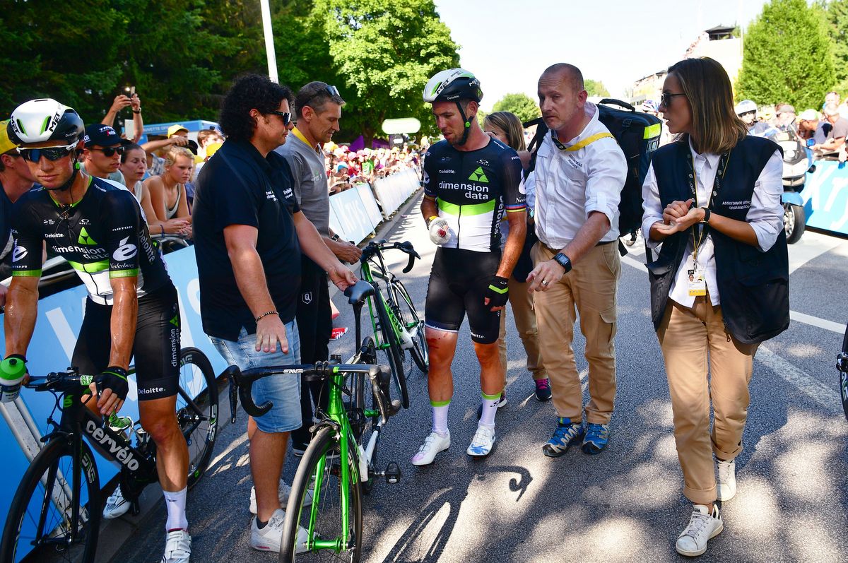 Mark Cavendish receiving assistance after the crash
