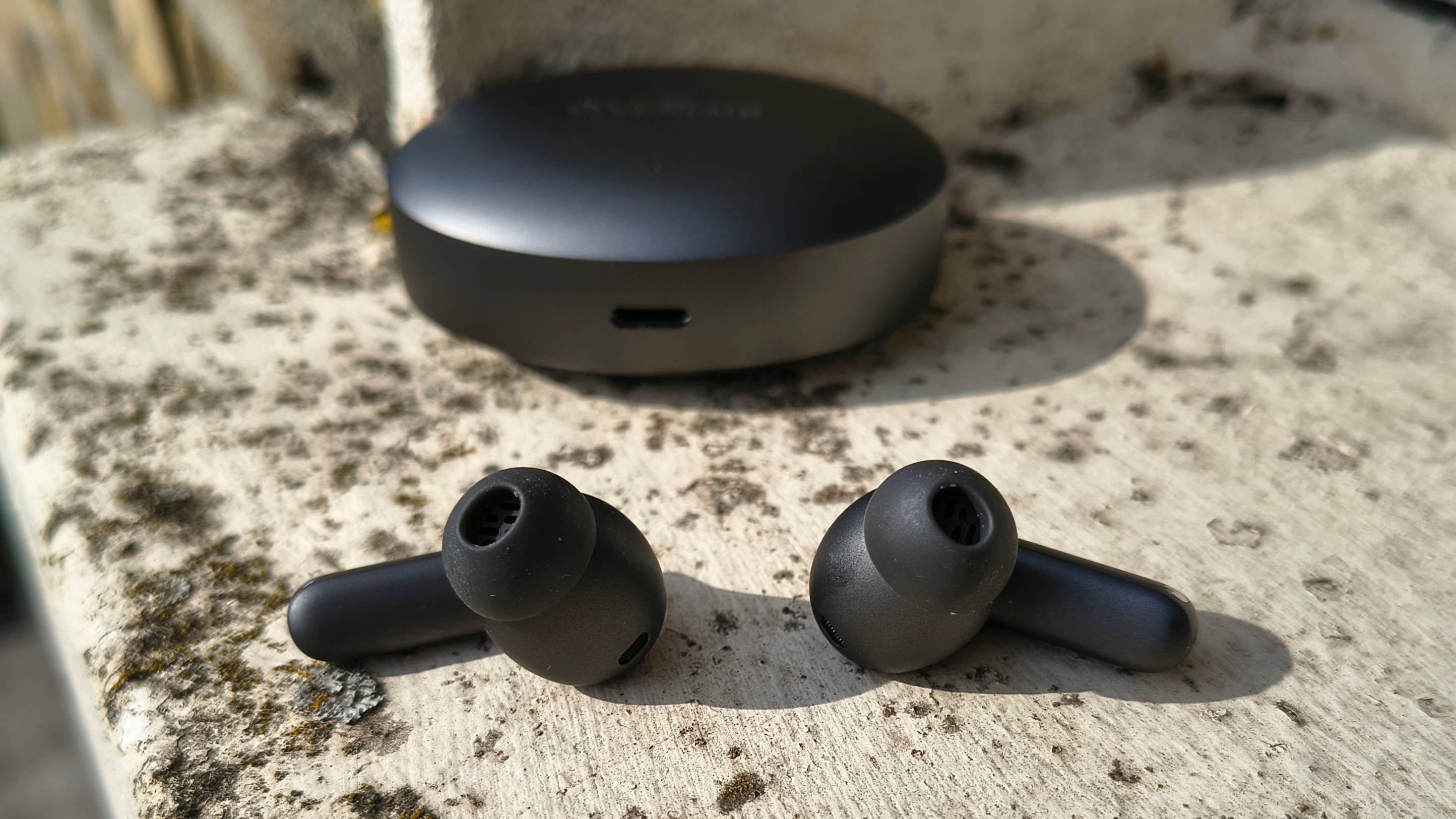 The OnePlus Buds 4 on a window sill.