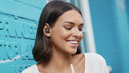 Jabra Elite 85t true wireless earbuds being worn by a smiling woman