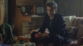 Anthony Lockwood leans forward as he sits in an armchair in Netflix's Lockwood & Co