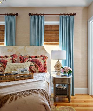 Beige bedroom with blue curtains and large headboard