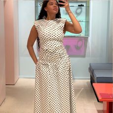 Imani wears Ganni Polka-Dot Satin Blouse and Long Skirt.