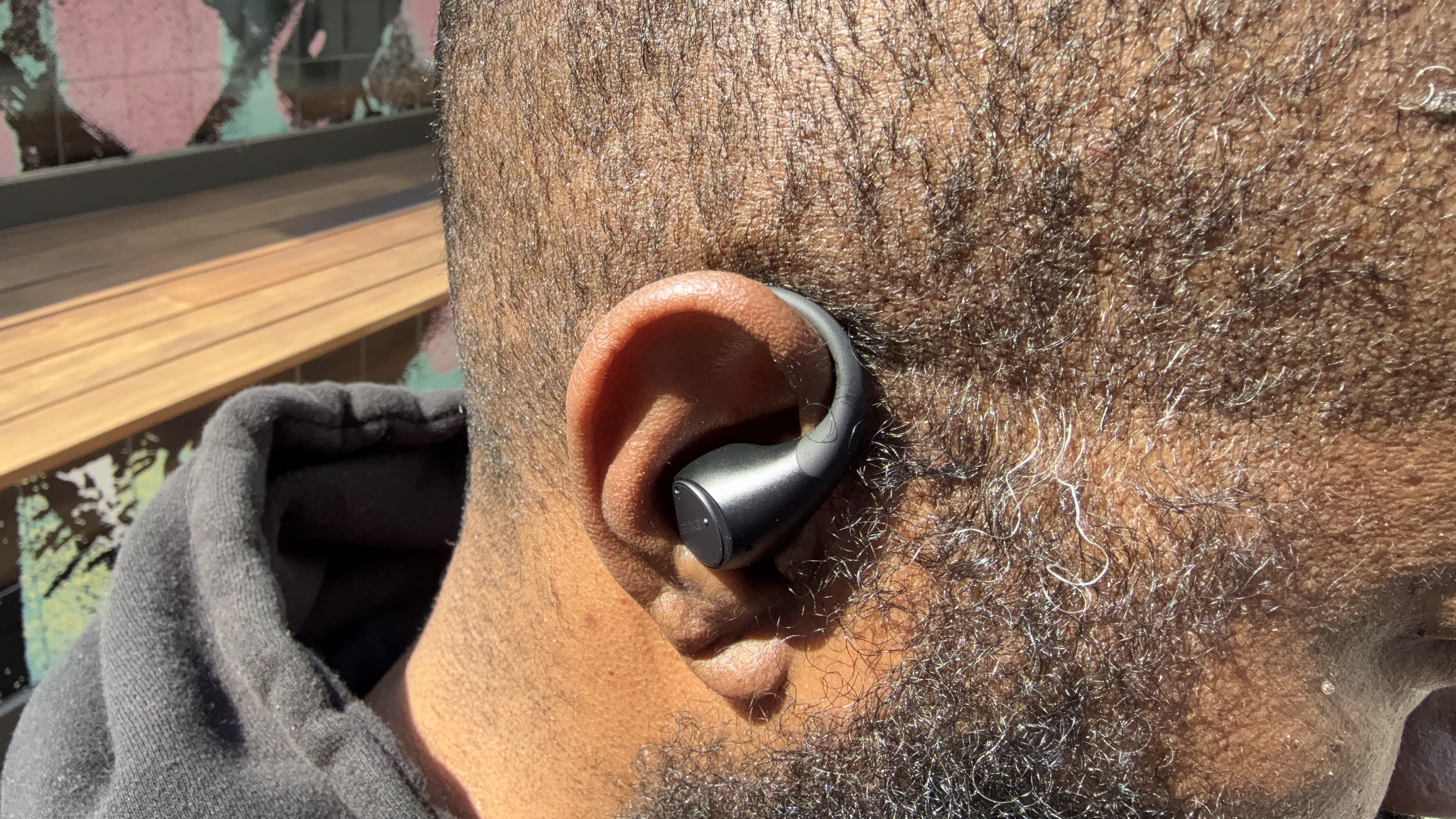 Image of the EarFun OpenJump being worn by Tshaka, showing the touch control surface positioning on his ear