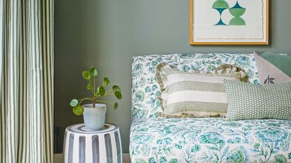 Green living room with botanical print sofa and geometric artwork