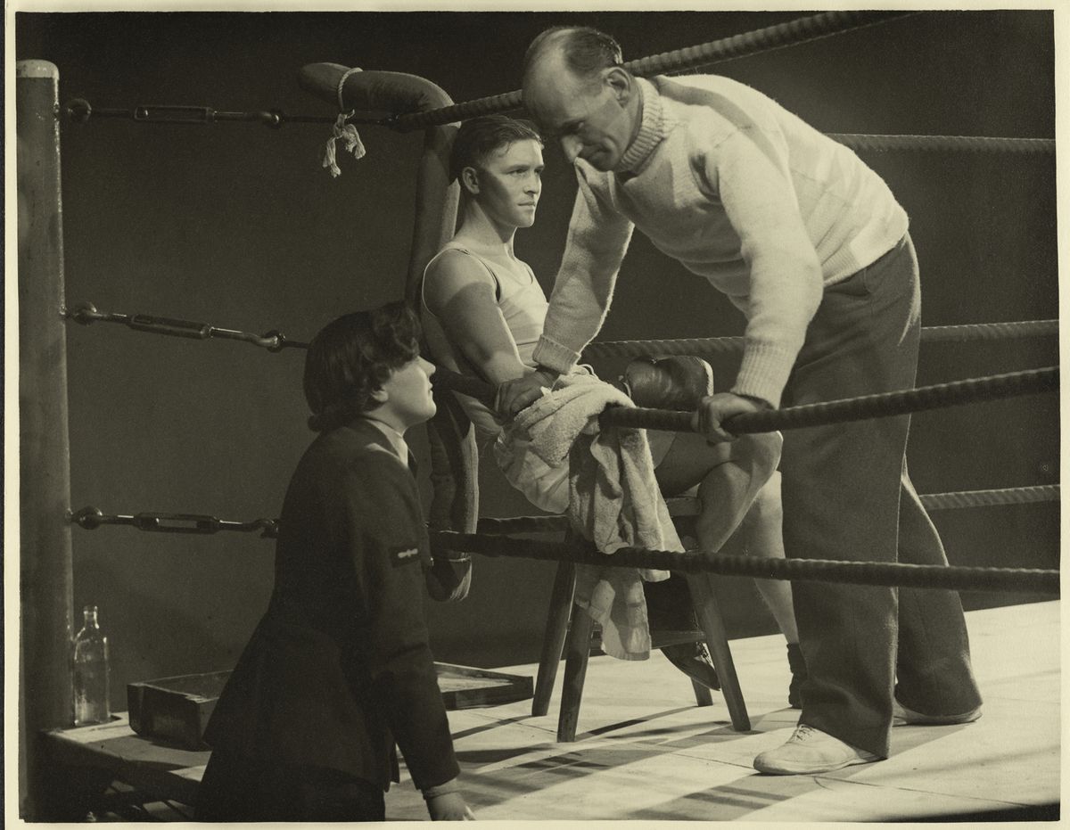 Still from the film 'The Big Pack' produced by the RAF Film Production Unit during the Second World War, showing a boxing ring with boxer and trainer, and a member of the WAAF