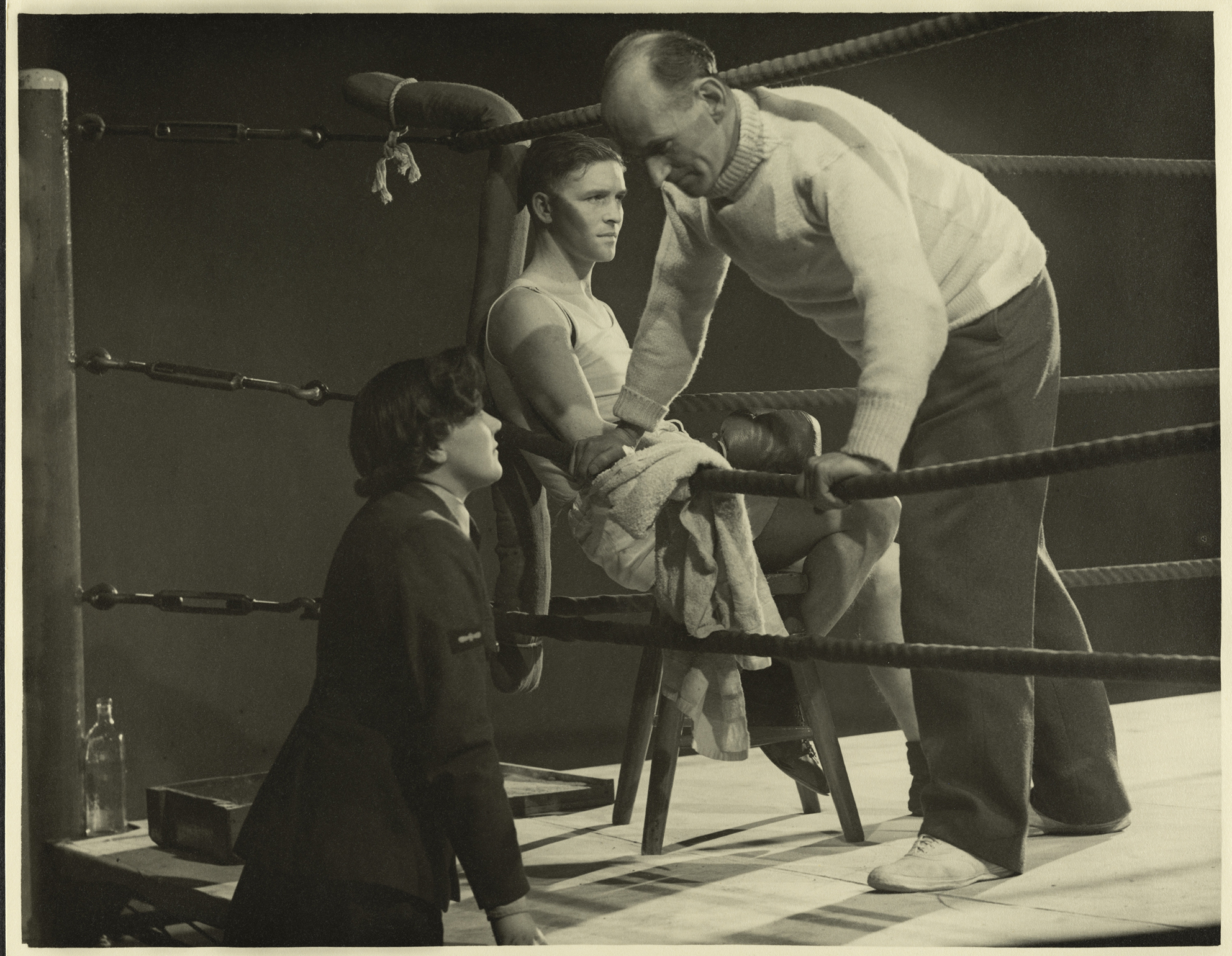 Still from the film 'The Big Pack' produced by the RAF Film Production Unit during the Second World War, showing a boxing ring with boxer and trainer, and a member of the WAAF