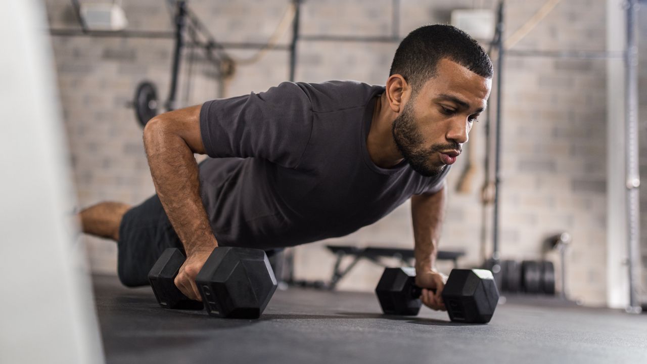 A man performing a renegade row 