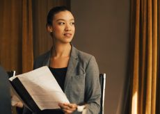 Thoughtful female lawyer with document looking away at law office