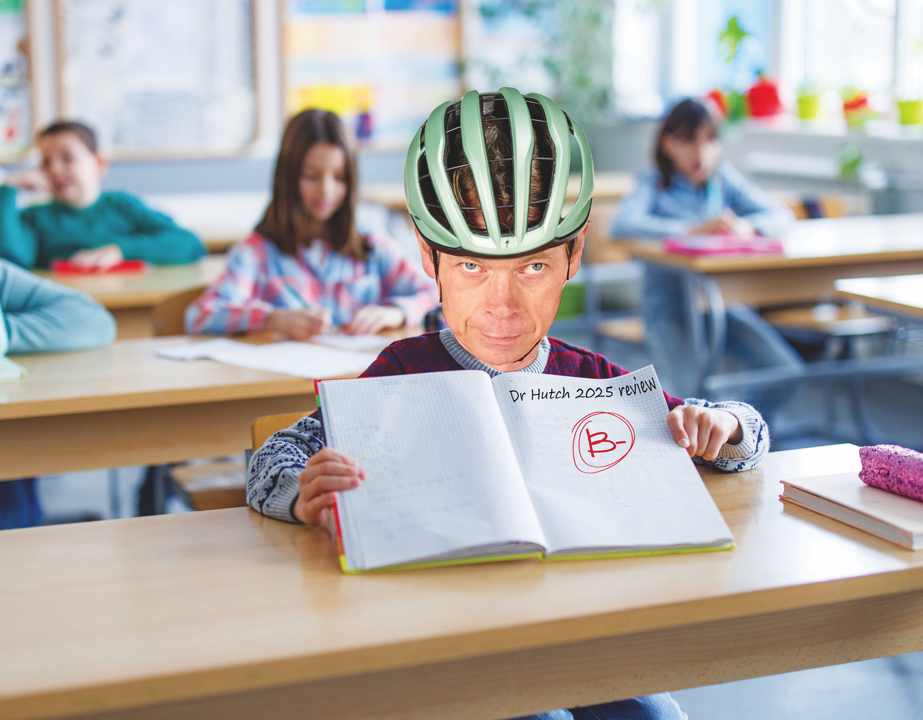 A man in a classroom with a bike helmet on