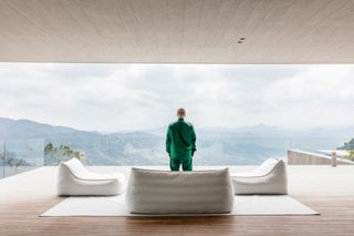Balvin on his vast terrace overlooking the Andes. It is furnished with white outdoor lounge chairs from the Ibiza collection by RH