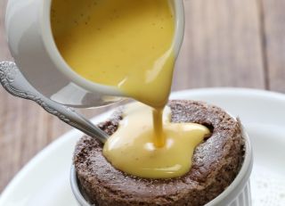 pouring creme anglaise onto chocolate souffle