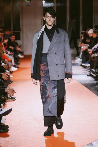 Model wearing coat with collaged print