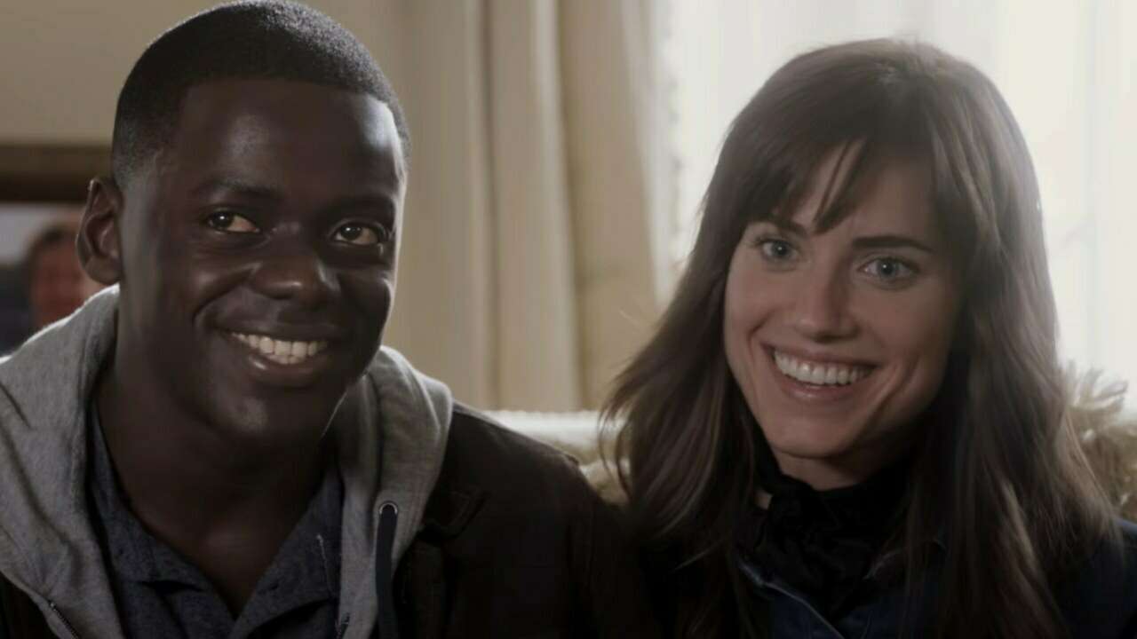 Daniel Kaluuya and Allison Williams sitting next to each other on a bed and smiling uncomfortably in Jordan Peele's 2017 hit, 