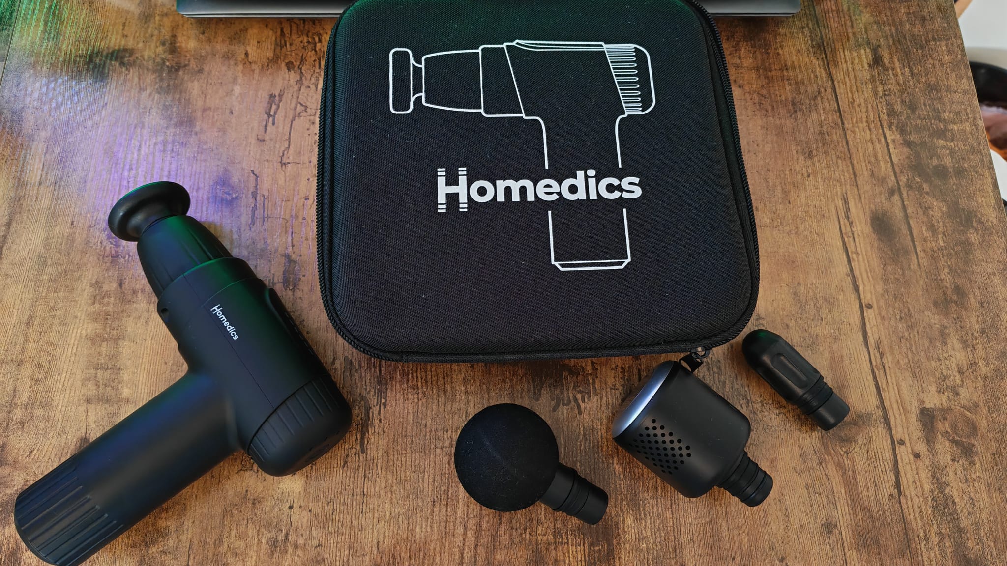 The Homedics Novo+ on a desk with its carry case and attachments