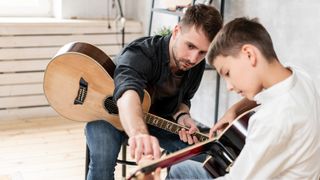Young boy getting a guitar lesson