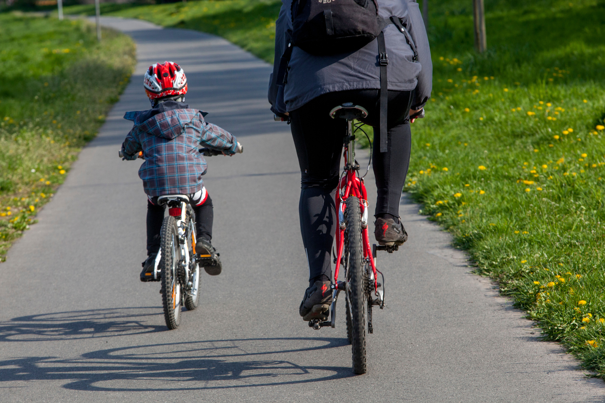 Image shows a kid cycling with thier parent