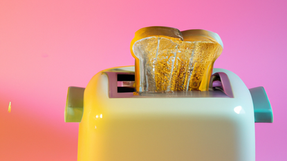 Yellow toaster with toast and pink background
