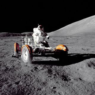 Apollo 17 mission commander Cernan makes a short checkout of the Lunar Roving Vehicle during the early part of the first Apollo 17 extravehicular activity at the Taurus-Littrow landing site. The picture was taken by Schmitt. The mountain in the right background is the east end of South Massif.