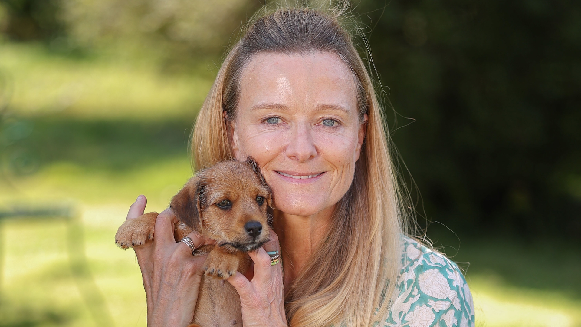 Lucy Macnamara, who has ADHD, holds a puppy in a garden