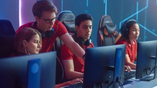 A group of young adults in an esports studio with gaming PCs