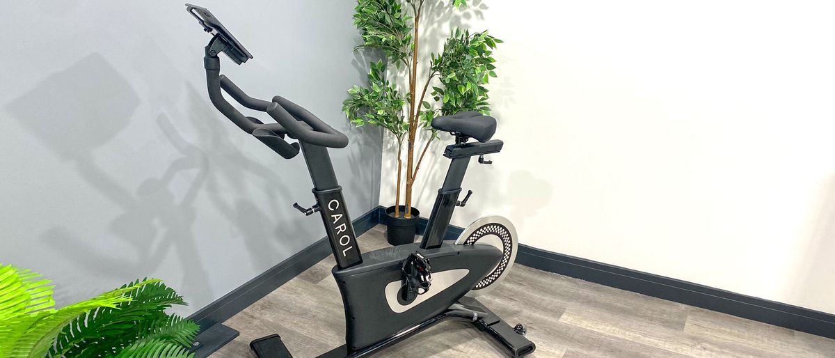 The CAROL Bike in a corner of a room surrounded by houseplants