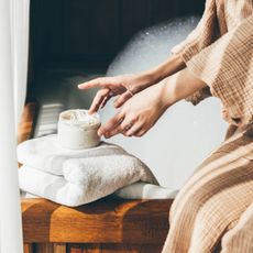 Close up of woman's hands using tub of moisturiser