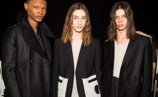 Three models pose in front of dark backdrop