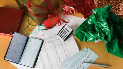 Photo of a checkbook, a calculator and crumpled wrapping paper.