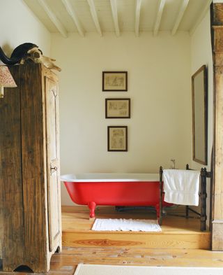 Bathroom with red roll top bath