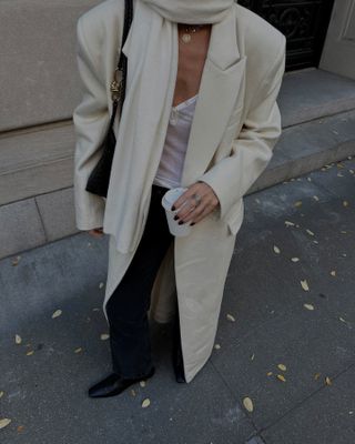 An image of stylist @hannahlewishstylist wearing a cashmere coat out in New York.