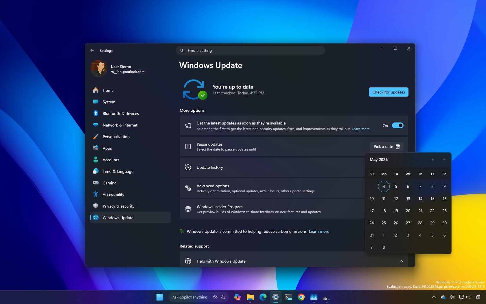 Windows Update settings window on a computer screen with a dark theme. The calendar is open, showing May 2025. The background is a gradient of blue, yellow, and purple.