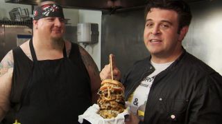 Adam Richman talking to the chef behind the OMG Burger