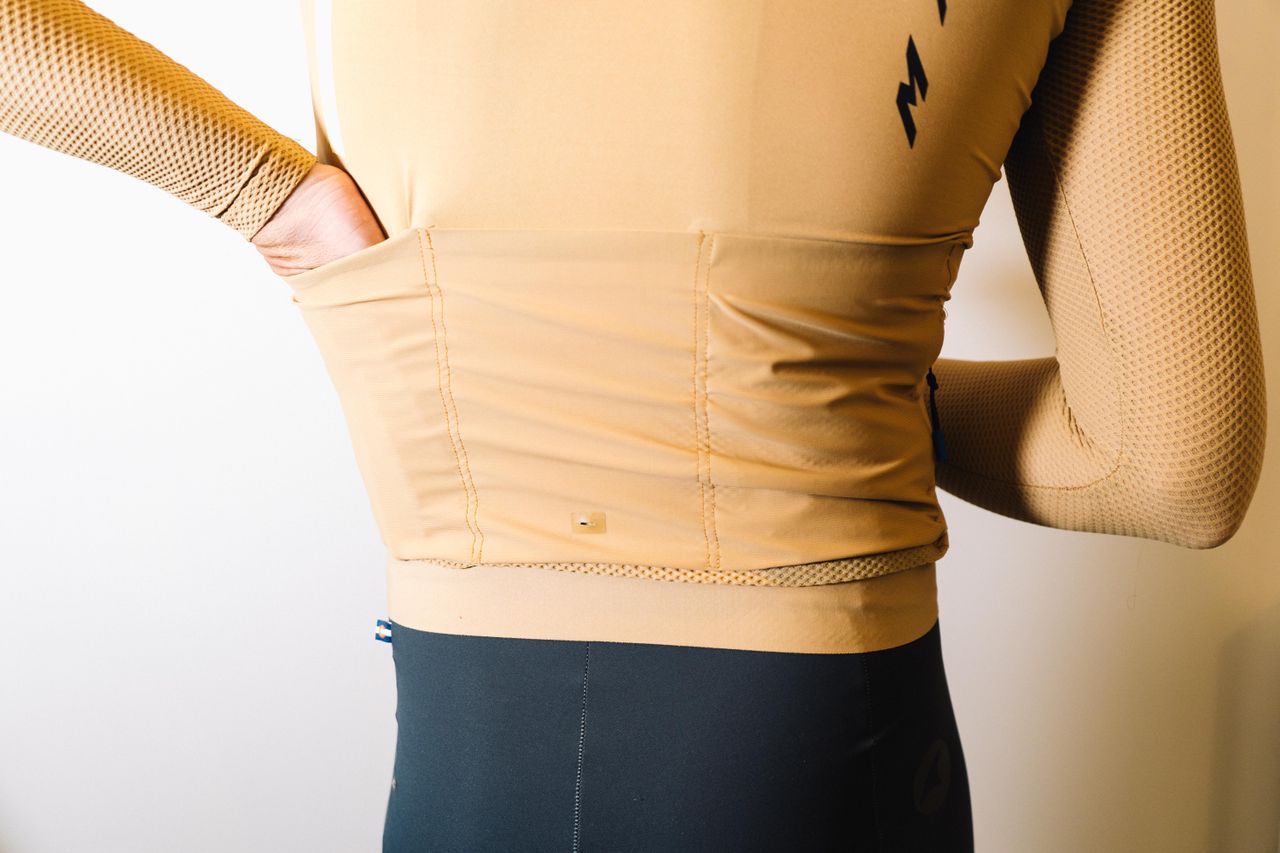A white man in a tan jersey against a white wall