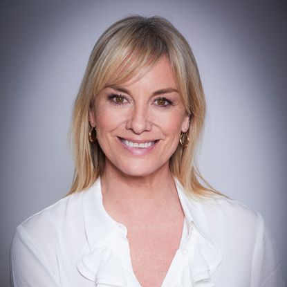 Tamzin looking at camera, smiling, wearing a white blouse