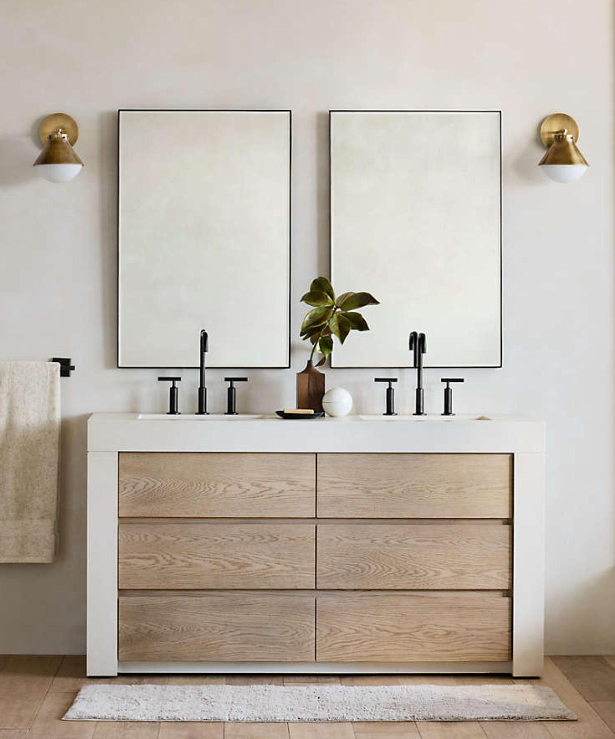 A white bathroom with a wooden vanity with a white border, black hardware, and two square mirrors