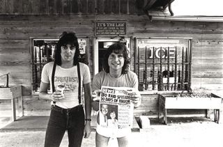 Pete Way and Phil Mogg (holding a tabloid newspaper)