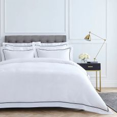 A bed dressed with white bed linen