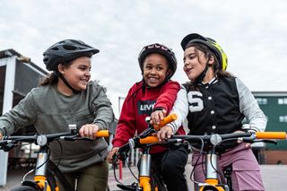 Three young girls on bikes at a City Academy