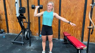 Lillie Bailey demonstrating the single-arm overhead press exercise with a dumbbell