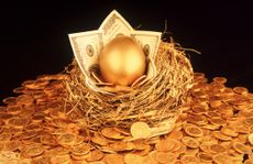 a golden egg surrounded by hundred-dollar bills in nest on top of a pile of gold coins