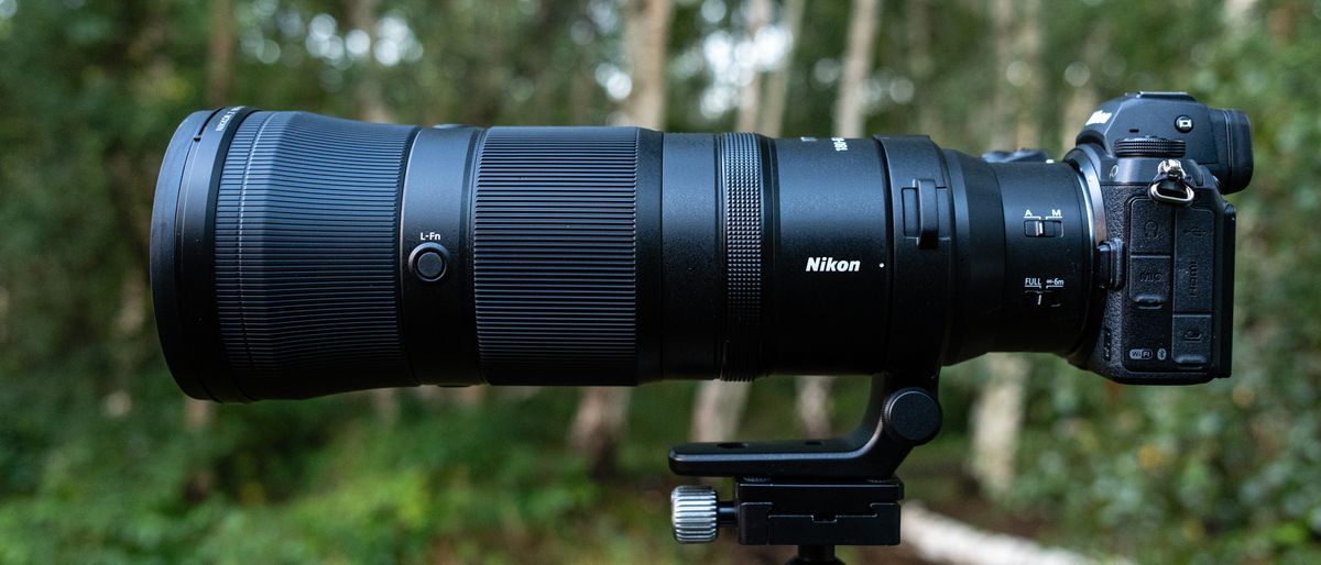 Nikkor Z 180-600mm f/5.6-6.3 VR mounted on a tripod with foliage and trees in the background