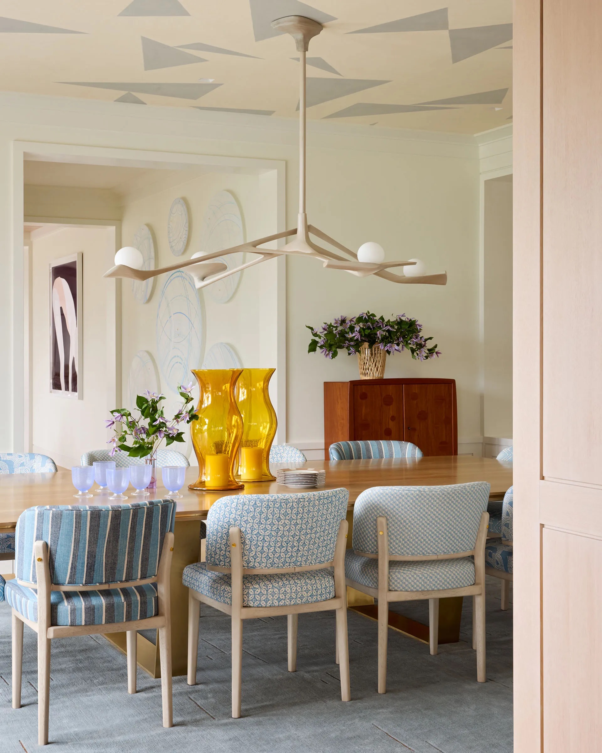 A contemporary dining room with the same chairs but covered in different fabrics