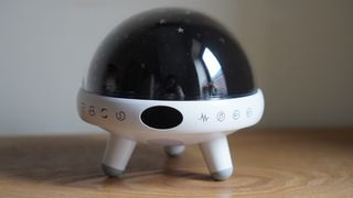 A Yachance Night Light star projector on a wooden surface.